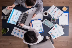 Profissionais analisando gráficos e relatórios em uma consultoria de marketing digital.