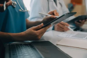 Profissionais de saúde utilizando tablets durante uma consultoria de comunicação para hospitais.