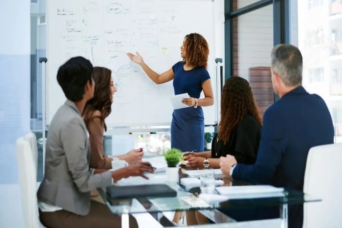 Profissional conduzindo treinamento corporativo para uma equipe em sala de reunião.