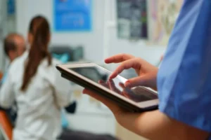 Profissional de saúde usando tablet para melhorar a comunicação hospitalar