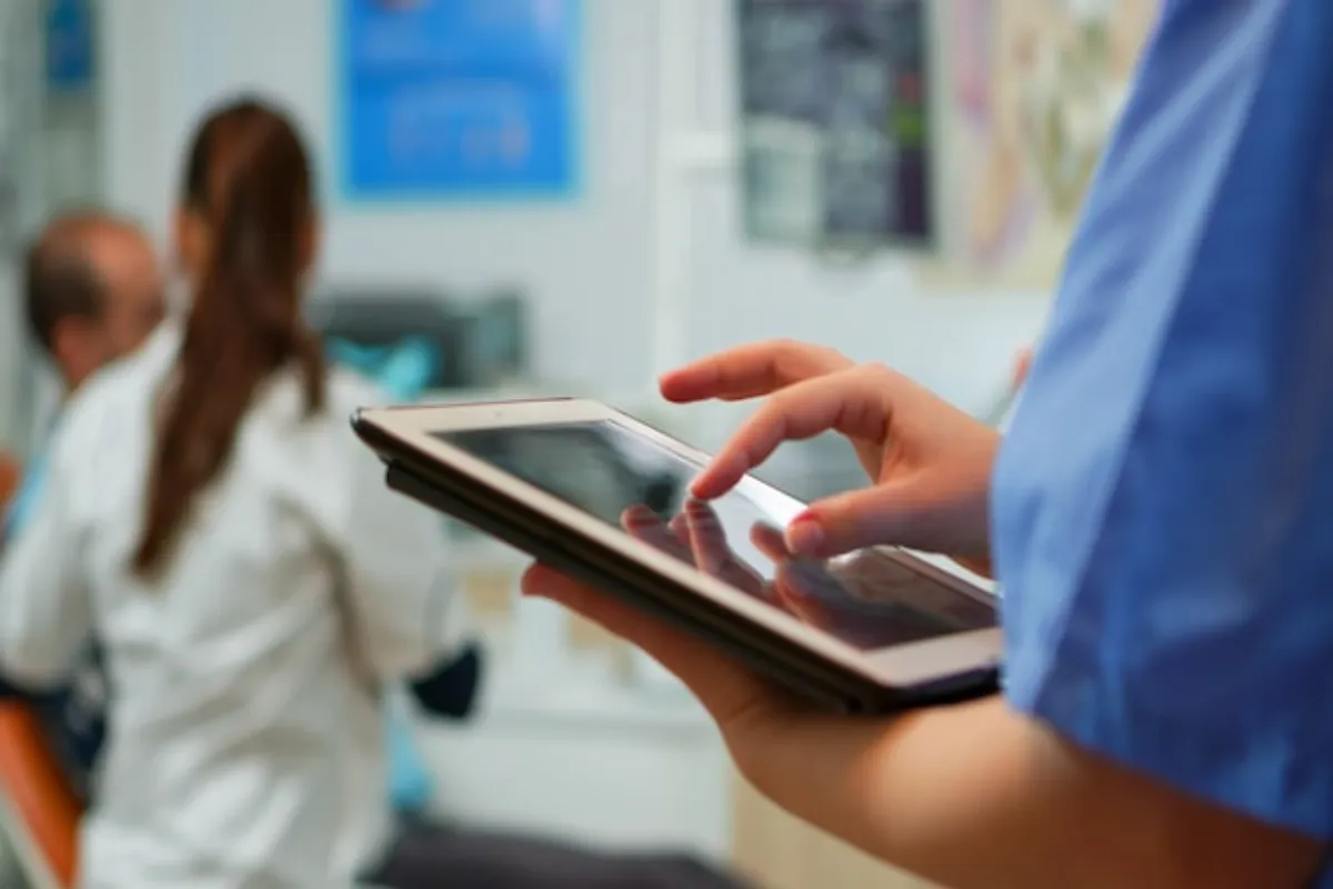 Profissional de saúde usando tablet para melhorar a comunicação hospitalar